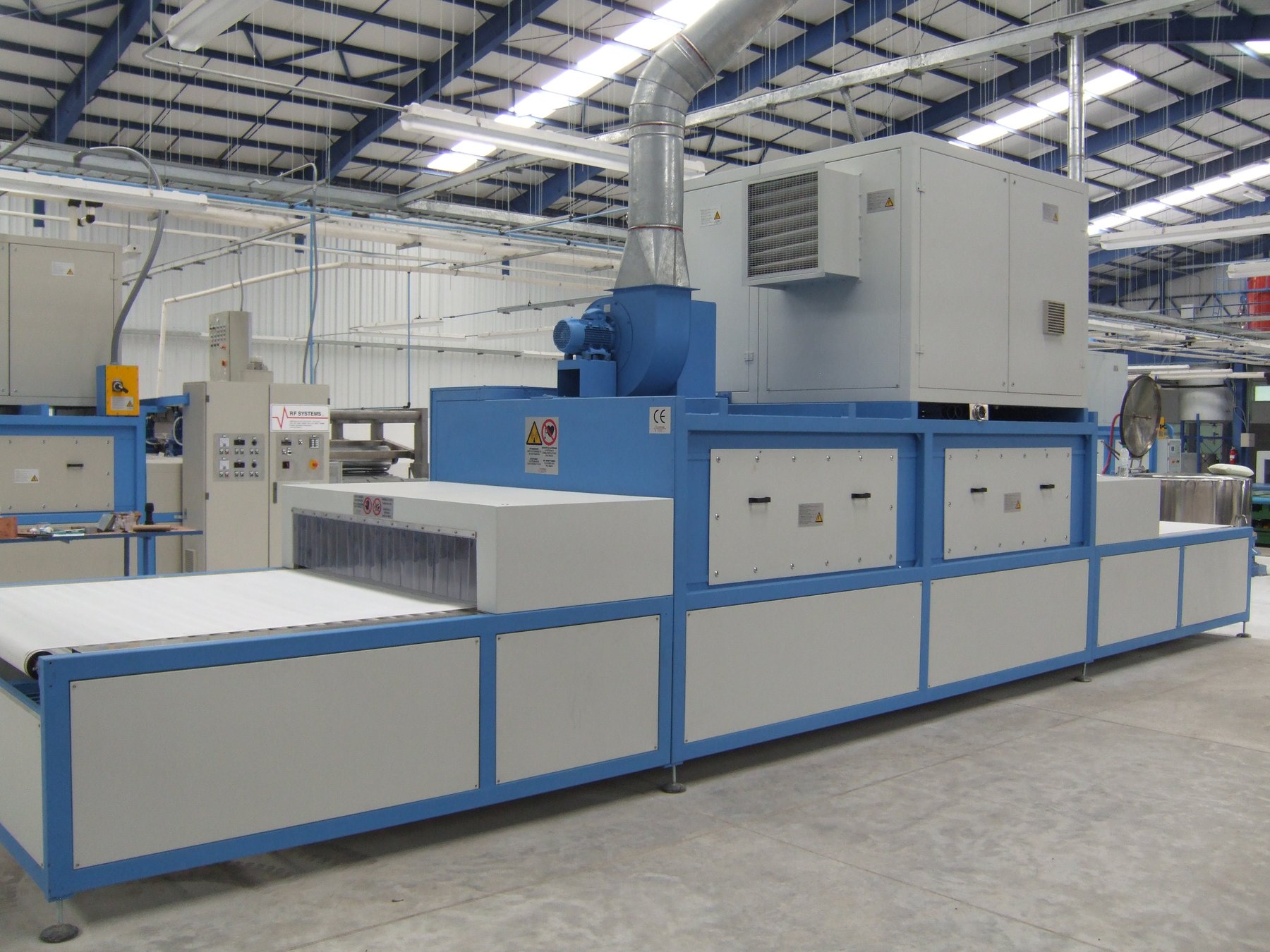Real high-frequency vulcanization tunnel on the production floor, Guatemala plant, with RF Systems control cabinet